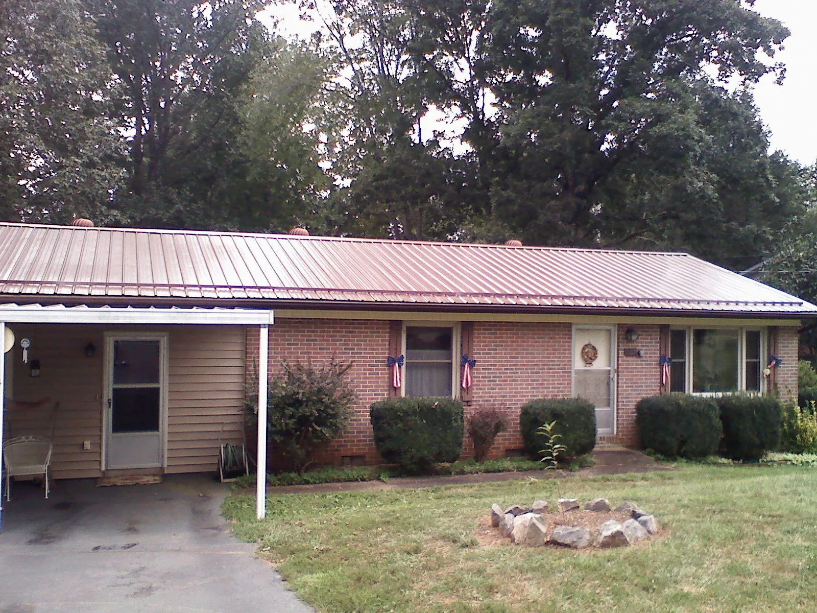 Bronze metal roof and carport on a brick ranch home — Roof Repair work by our crew in Empire